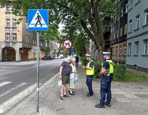 policjanci rozmawiają z kobietami przy przejściu dla pieszych