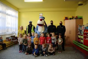 Zdjęcie grupowe przedszkolaków ze Sznupkiem i policjantami