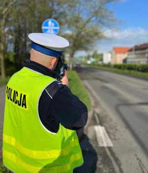 Na zdjęciu widoczny policjant wykonujący pomiar prędkości