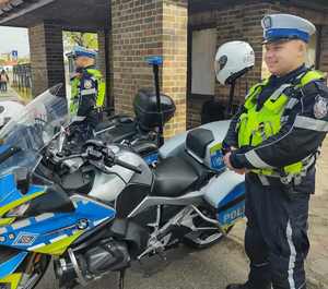 Na zdjęciu dwóch policjantów ruchu drogowego wraz z motocyklami służbowymi.