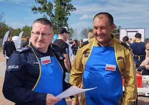 Na zdjęciu Komendant Miejski Policji w Bytomiu wraz z Komendantem Miejskim Państwowej Straży Pożarnej w Bytomiu.  Na mundurach założone niebieskie fartuchy.