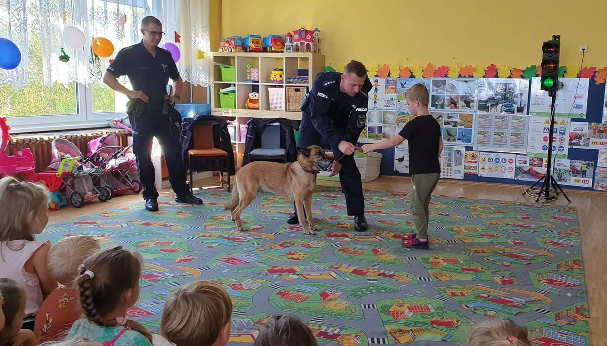 Policjanci, pies służbowy i przedszkolak.