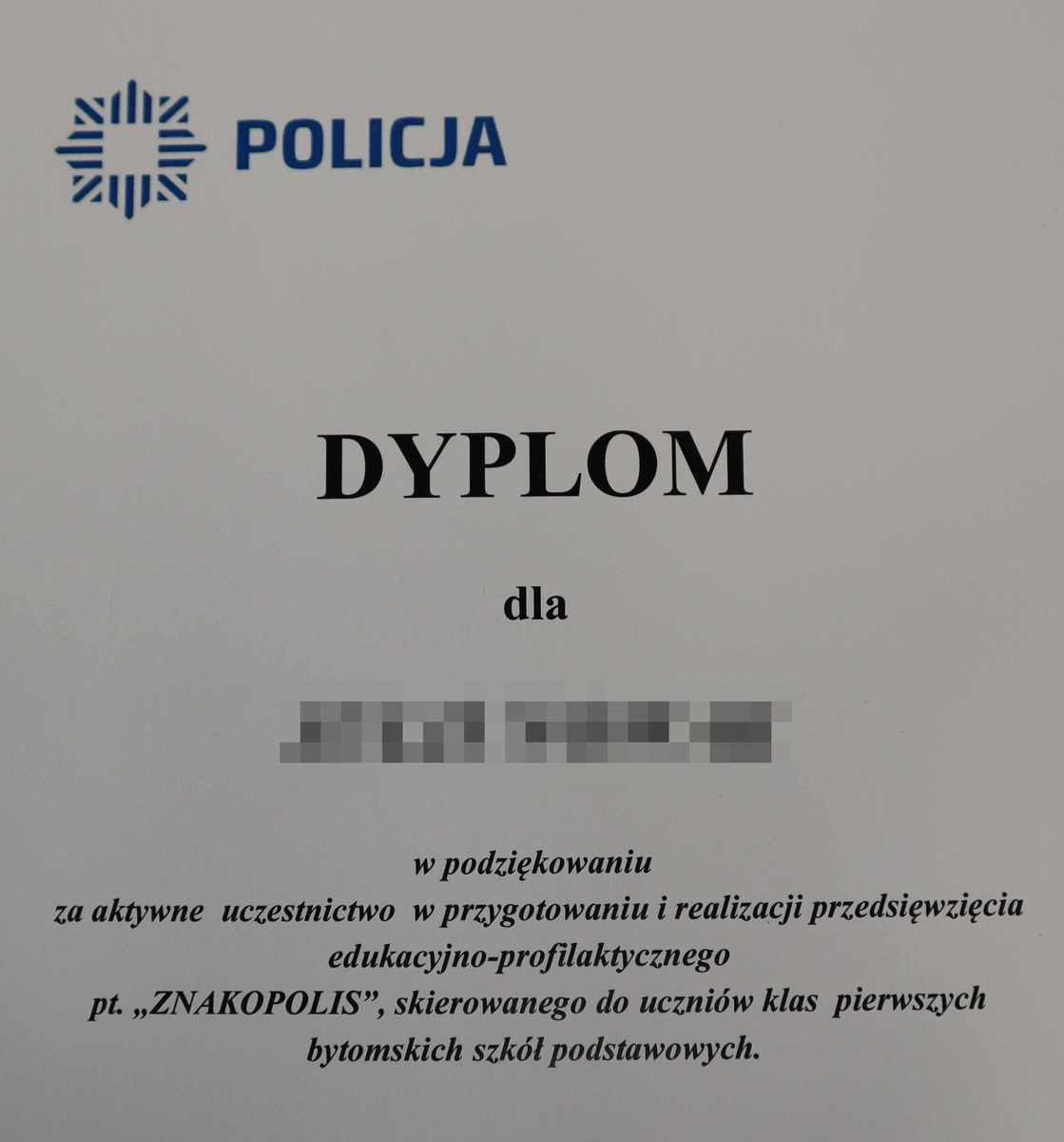 Dyplom z napisem Policja i podziękowaniami za aktywne uczestnictwo w przygotowaniu i realizacji przedsięwzięcia edukacyjno-profilaktycznego Znakopolis skierowanego do uczniów klas pierwszych bytomskich szkół podstawowych.