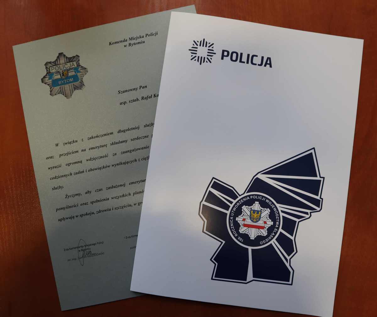 Zdjęcie przedstawia podziękowania i obwolutę z logo śląskiej Policji