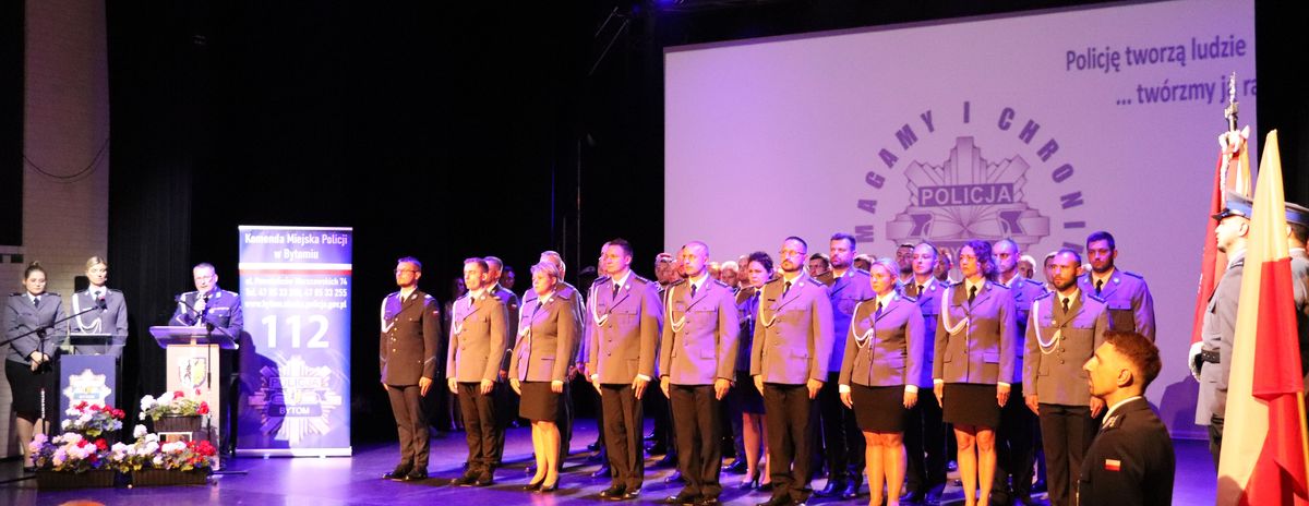 Na zdjęciu umundurowani policjanci stojący na scenie 