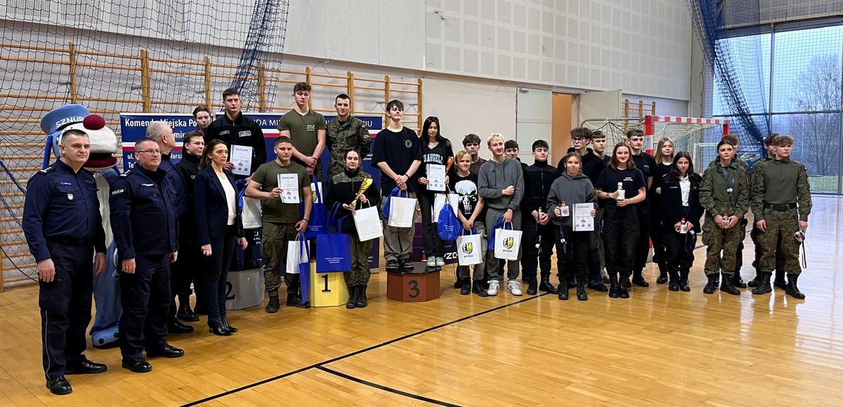 na zdjęciu uczniowie klas mundurowych, część z nich stoi na podium obok policjanci