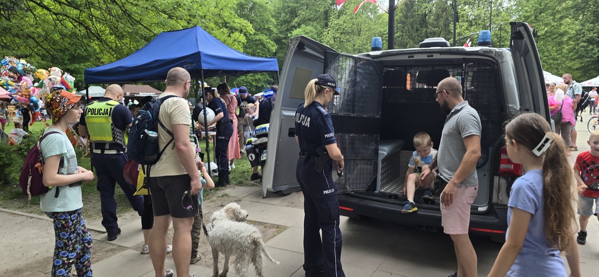 na zdjęciu policjanci, radiowóz oraz zgromadzone osoby