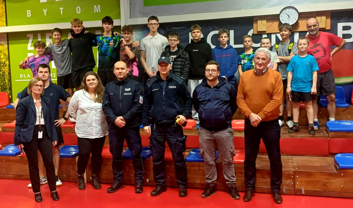 na zdjęciu dwaj policjanci pomiędzy osobami dorosłymi i dziećmi pozujący do zdjęcia 