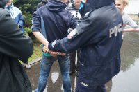 Policjantka demonstruje uczniom jak zakładać kajdanki na ręce z tyłu.