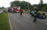 Miejsce dachowania osobowej toyoty, strażacy zamiatają szkoło z szyb auta.