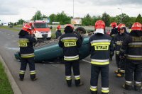 Strażacy przy toyocie, która dachowała.