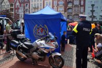 Mundurowy oraz policyjny motor przy namiocie tematycznym KMP Bytom na bytomskim rynku.