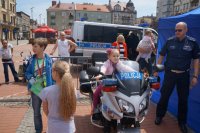 Dziewczynka siedzi na policyjnym motorze.