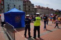 Dwóch policjantów obserwuje imprezę dla dzieci na bytomskim rynku.