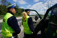 Policjant i policjantka z bytomskiej drogówki stoją przy samochodzie kontrolowanego kierowcy busa.