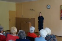 Seniorzy słuchają prelekcji policjantki