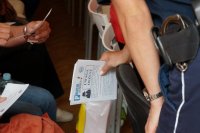 Policjantka trzyma w ręce ulotką pt. &quot;uwaga oszust&quot;