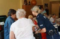 Policjantka odpowiada seniorom na ich pytania.