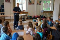 Policjant objaśniający dzieciom przepisy ruchu drogowego