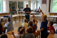 Dzieci zgłaszające się do odpowiedzi na pytanie policjanta