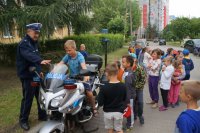 Chłopiec siedzący na policyjnym motorze