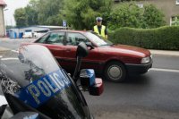 Policjant drogówki kontrolujący stan trzeźwości kierowcy auta