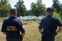 Policjant i Strażnik Miejski obserwują basen miejski