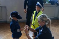 Policjantka pokazuje dzieciom sprzęt służbowy
