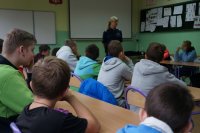 Gimnazjaliści przysłuchują się prelekcji prowadzonej przez policjantę
