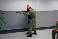 Uczeń w pozycji stojącej mierzy z karabinu