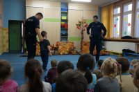 Policjant tłumaczy chłopcu zasady bezpieczeństwa