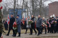 Komendant niosący kwiaty przed złożeniem ich pod pomnikiem