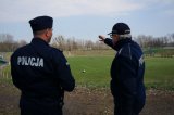 Policjanci zabezpieczający mecz a w tle murawa stadionu