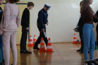 Policjant WRD objaśnia tor przeszkód a w tle uczestnicy konkursu