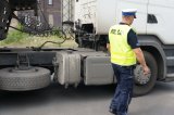 Policjant w kamizelce odblaskowej przy ciężarówce