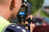 Policjant drogówki sprawdzający miernikiem prędkość pojazdów