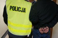 Policjant prowadzi zatrzymanego