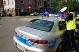 Policjant drogówki stoi przy radiowozie