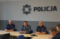 trzech policjantów siedzących za stołem