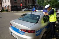 policjant pisze na dachu radiowozu