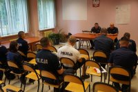 grupa policjantów siedzi na krzesłach w sali