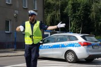 Policjant kieruje ruchem zabezpieczenia 76. Tour de Pologne