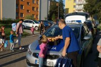 dziecko wraz z ojcem zabiera z pokrywy silnika radiowozu jabłko