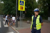 policjant stoi przy przejściu dla pieszych