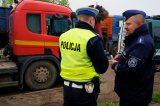 dwóch policjantów rozmawia przed ciężarówką