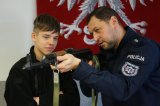 policjant pokazuje broń chłopcu