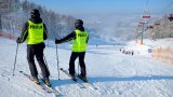 policjanci na nartach zjeżdżają ze stoku