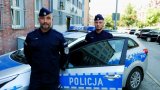 dwóch policjantów z Bytomia pozuje do zdjęcia na tle radiowozu