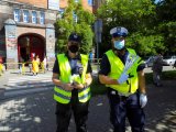 policjant i strażnik miejski trzymają odblaski