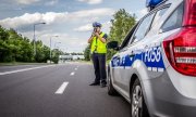 policjant stoi przy radiowozie